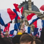 people holding France flag in the street