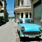 teal vehicle parked beside building