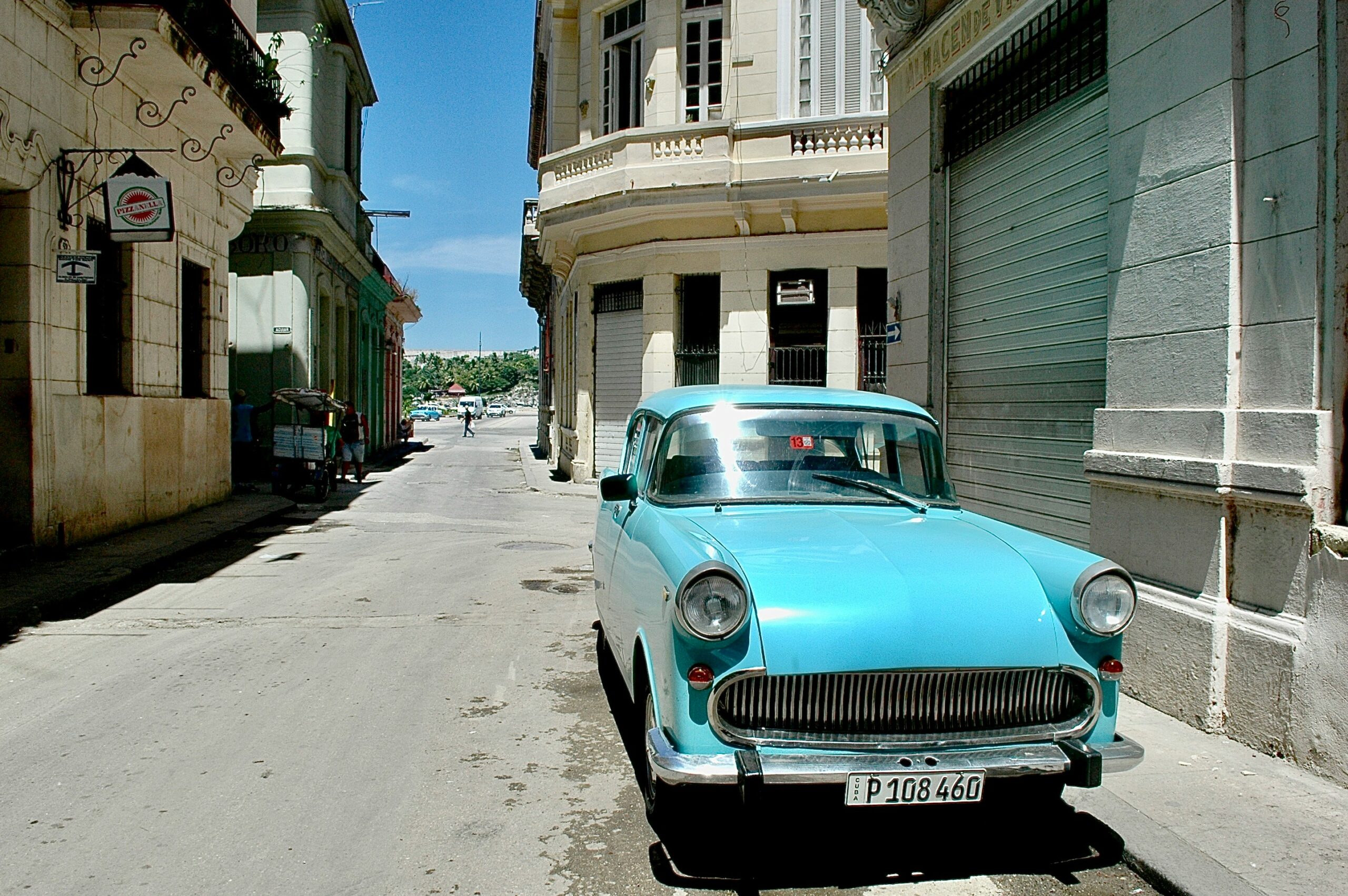 teal vehicle parked beside building