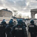group of people in black jacket standing near white concrete building during daytime