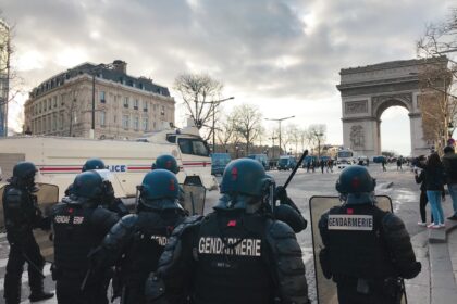 group of people in black jacket standing near white concrete building during daytime