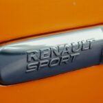 a close up of a sports badge on an orange sports car