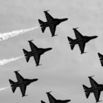 a group of fighter jets flying through a cloudy sky
