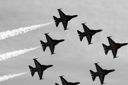 a group of fighter jets flying through a cloudy sky