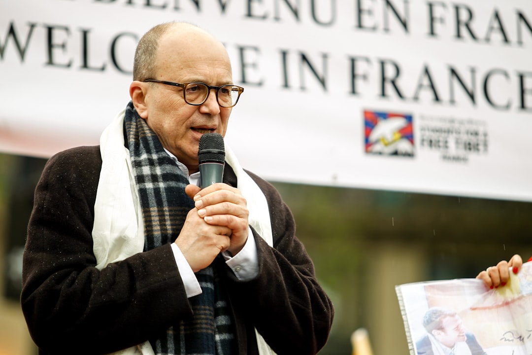 a man speaking into a microphone in front of a sign