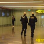 Two police officers walking through an airport terminal