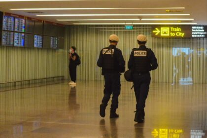 Two police officers walking through an airport terminal