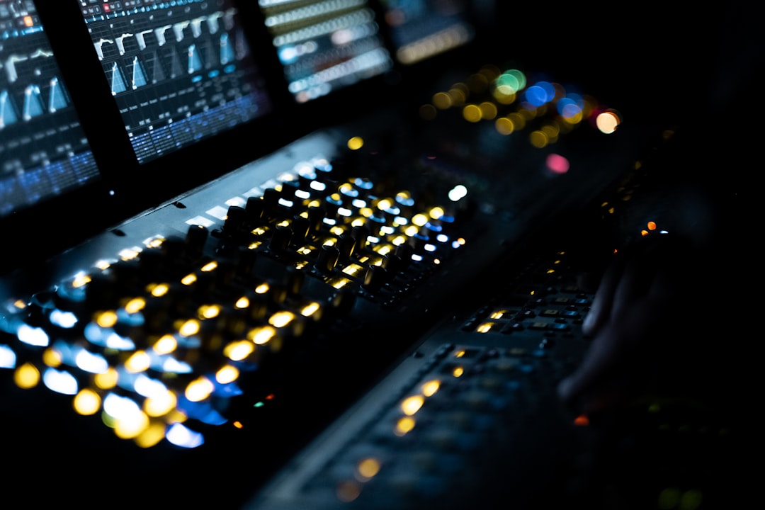 A close up of a computer keyboard and two monitors