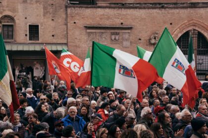 A large group of people holding flags in front of a building