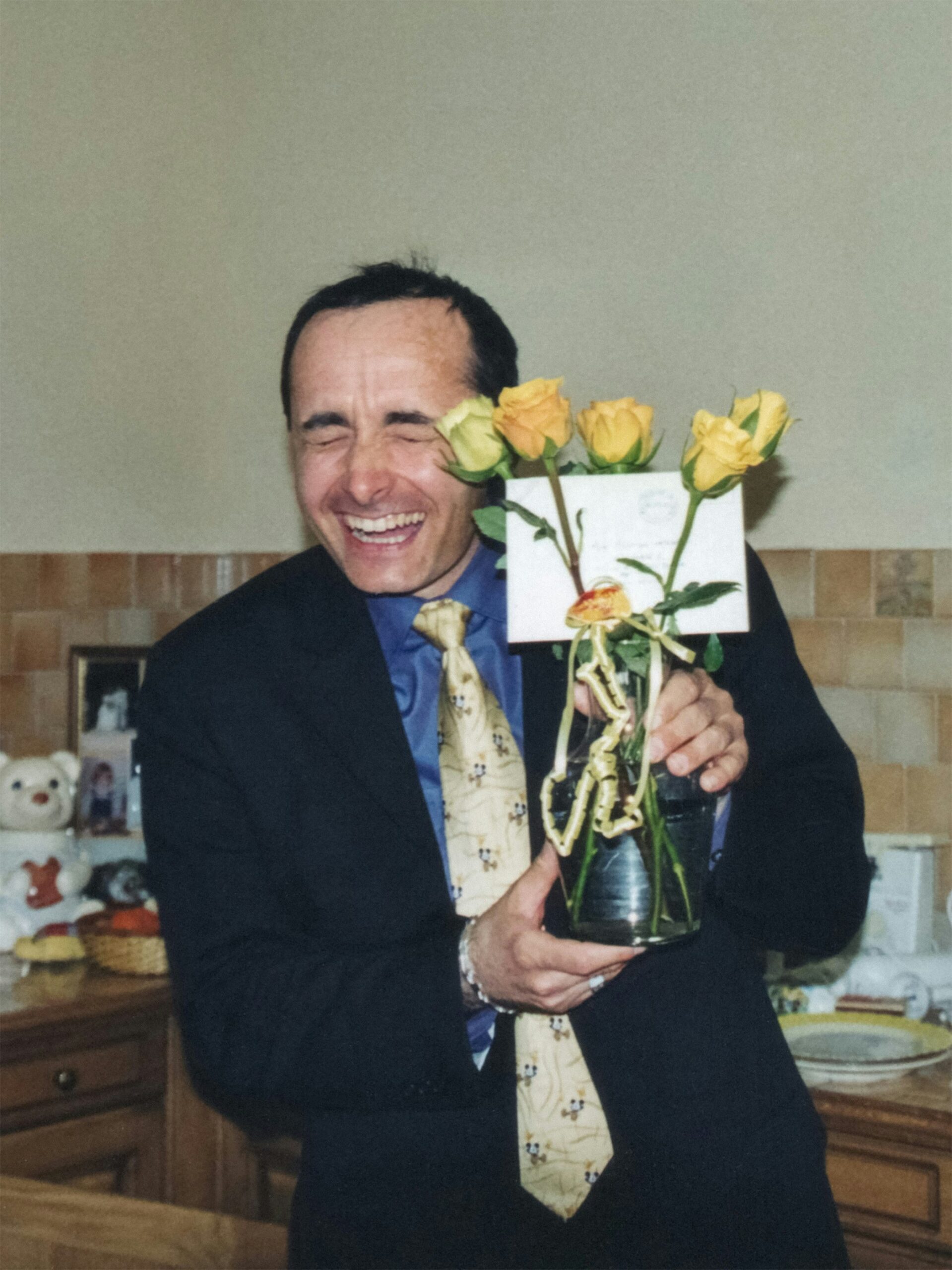 Man happily shows off a bouquet of yellow roses.