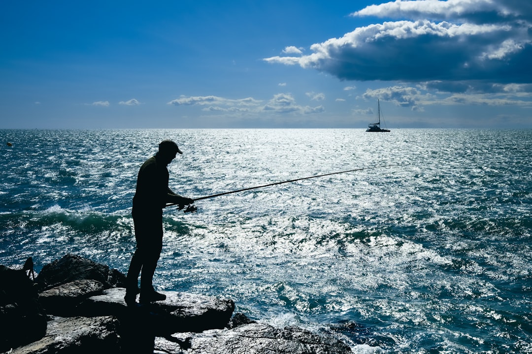 A fisherman is fishing by the sea.