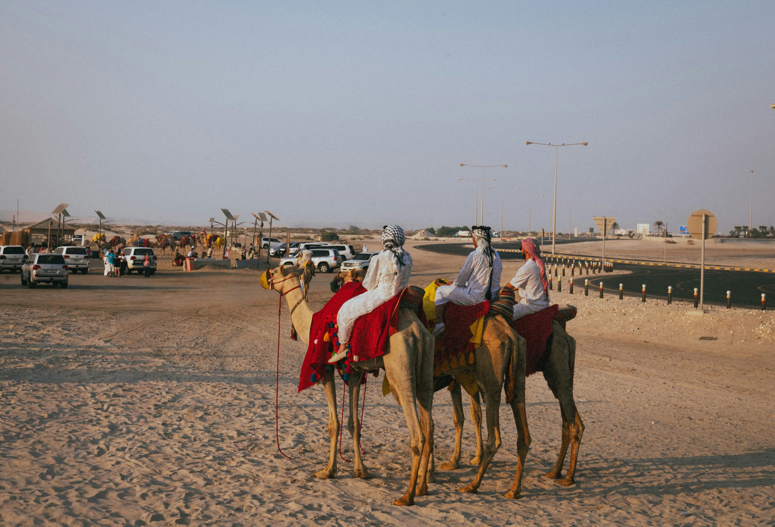 People riding camels in a desert landscape