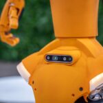 Close-up of an orange robot with a sensor array.