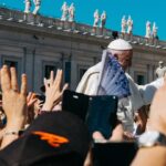 Pope surrounded with people during daytime