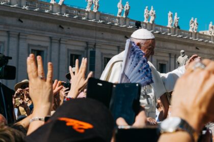Pope surrounded with people during daytime