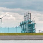 white and blue factory under white clouds during daytime