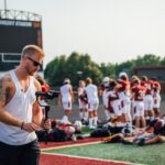 a man with a camera on a football field