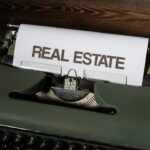 a close up of a typewriter with a real estate paper on it