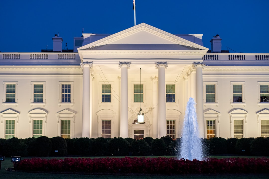 a white building with a fountain in front of it with White House in the background