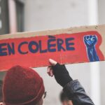a person holding a sign that says en colere