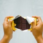 a person holding a piece of chocolate in their hands