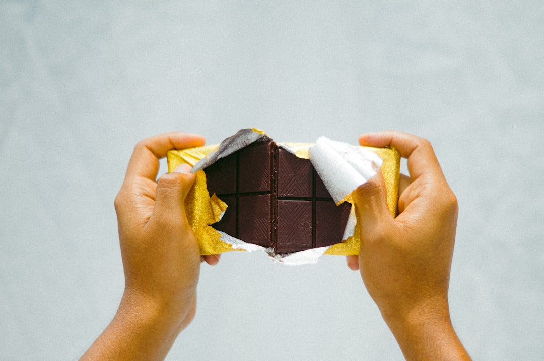 a person holding a piece of chocolate in their hands