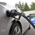 an electric car being charged at a gas station
