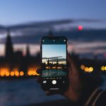 a person taking a picture of a city at night