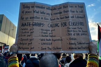a person holding a cardboard sign in front of a crowd