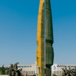 A man walks past a monumental sculpture.