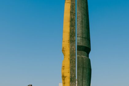 A man walks past a monumental sculpture.