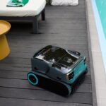 Robotic pool cleaner on wooden deck by pool