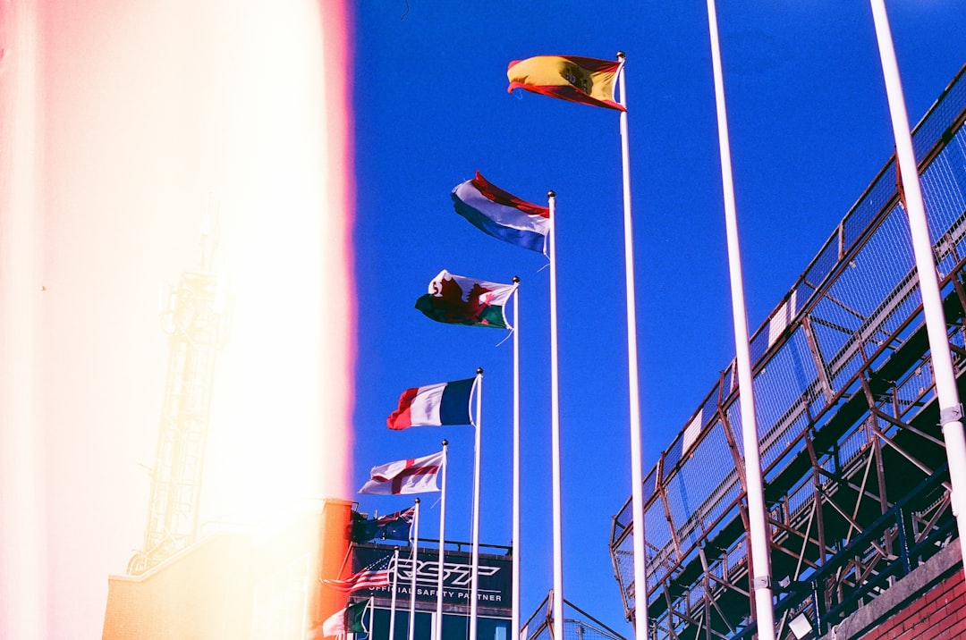 Several national flags flying against a blue sky.