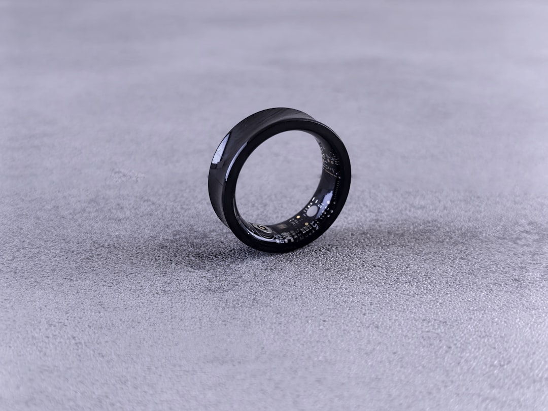 A black ring with white speckles on a gray surface