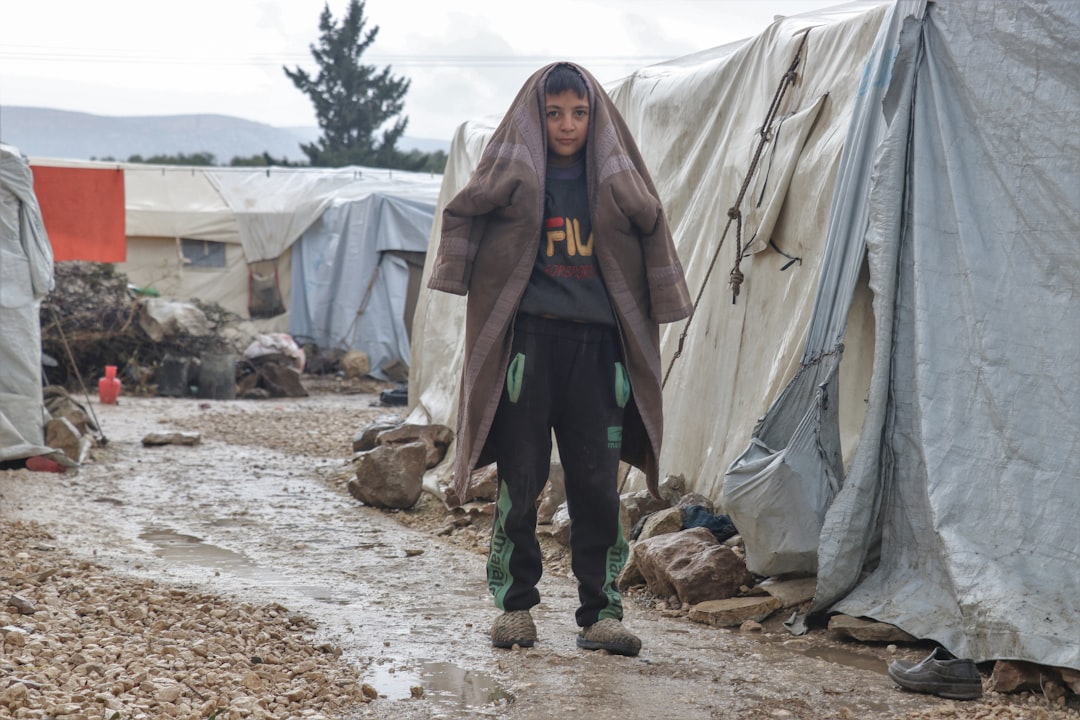 Young boy wrapped in blanket in refugee camp