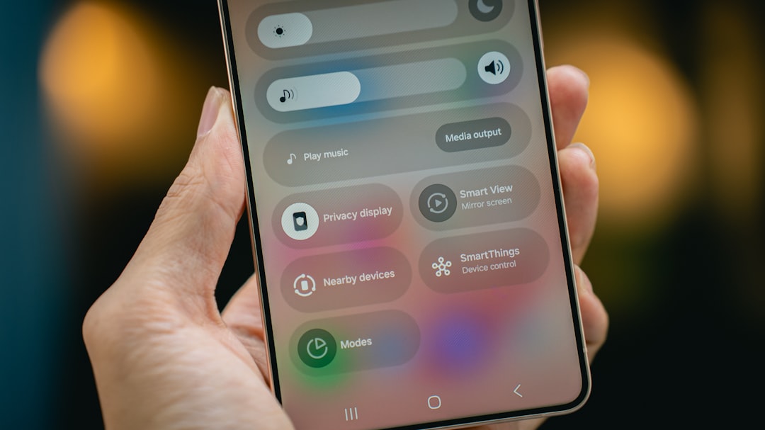 Person holding a smartphone displaying a settings menu