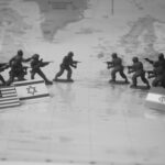 Toy soldiers facing each other with flags on map