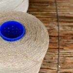 Two spools of thread on a textured surface.