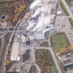 an aerial view of a factory with smoke coming out of it