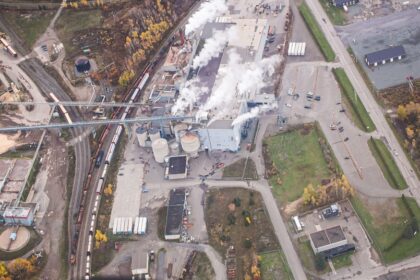 an aerial view of a factory with smoke coming out of it