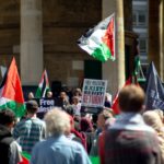 a large group of people holding flags and signs