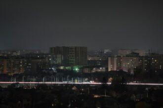 a city skyline at night with buildings lit up