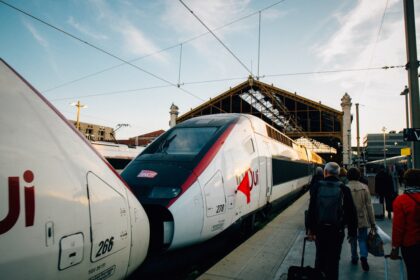 A group of people standing next to a train