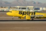A yellow spirit airplane on the runway of an airport