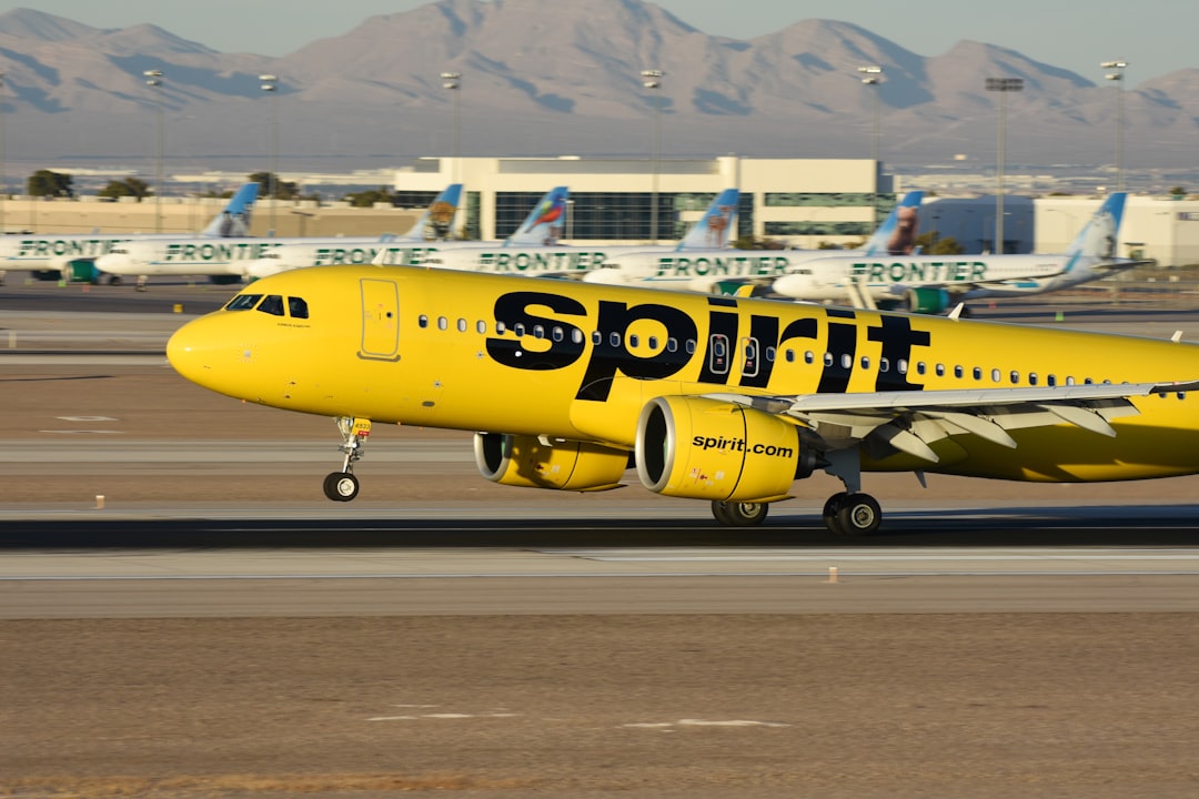 A yellow spirit airplane on the runway of an airport