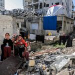 A group of people standing next to a pile of rubble