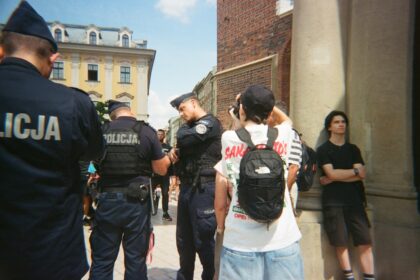 Police officers stand near civilians on a street.