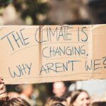 a group of people holding a sign that says the climate is changing why aren '