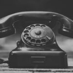 black rotary phone on gray textile