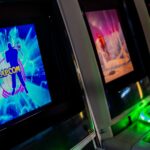 Row of glowing arcade game machines in darkness